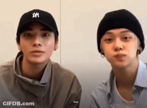 Two Young Men Sitting Next To Each Other Wearing Hats GIF