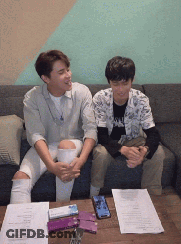 Two Young Men Sitting On A Couch With One Wearing A Shirt That Says ' Savage ' GIF