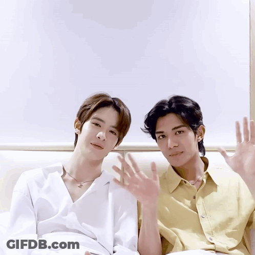 Two Young Men Sitting With Hands Up GIF
