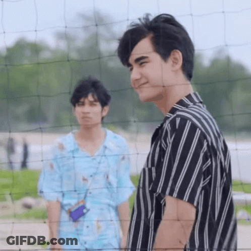 Two Young Men Standing By Volleyball Net On Beach GIF
