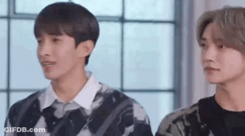 Two Young Men Standing By Window GIF