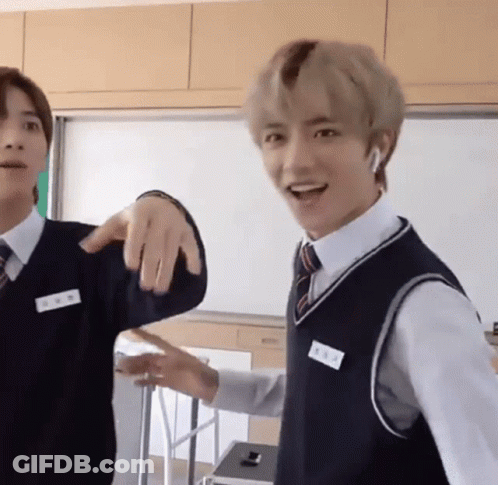 Two Young Men Standing In Classroom One In Vest And Tie GIF