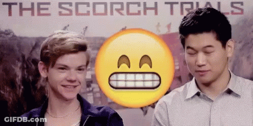 Two Young Men Standing In Front Of The Scorch Trials Poster GIF