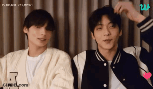 Two Young Men Standing Next To Each Other Looking At Camera GIF