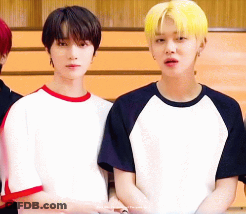 Two Young Men Standing Next To Each Other One With Yellow Hair GIF