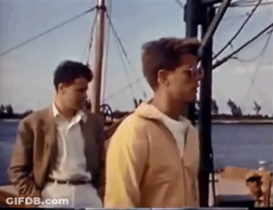 Two Young Men Standing On A Boat GIF
