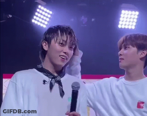 Two Young Men Standing On Stage With Microphone GIF