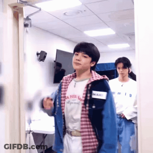 Two Young Men Standing One Wearing NM Shirt GIF