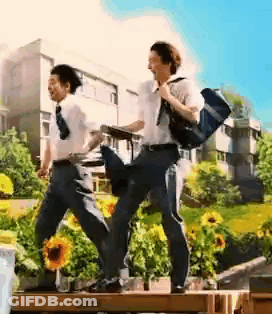 Two Young Men Walking Across Wooden Bridge GIF