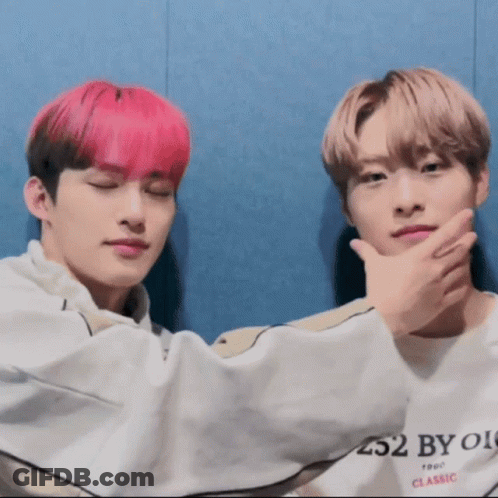 Two Young Men With Pink Hair Sitting Next To Each Other GIF