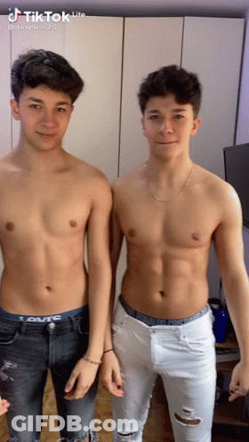 Two Young Men Without Shirts Standing Together GIF