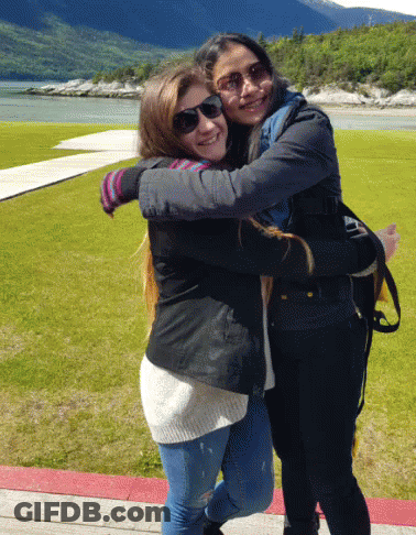 Two Young Women Hugging In Front Of Lake GIF
