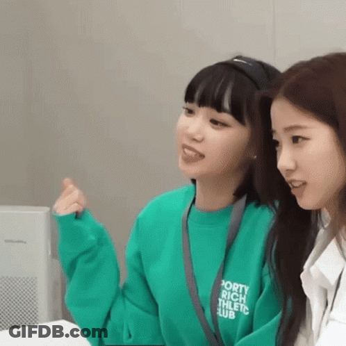 Two Young Women Sitting Next To Each Other One In Green Sweatshirt GIF