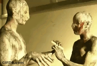 Two Zombies Are Standing Next To Each Other In Front Of A Mirror . One Of The Zombies Is Holding A Knife . GIF