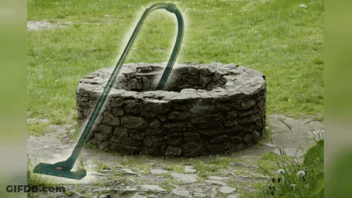 Vacuum Cleaner In Front Of Stone Well GIF