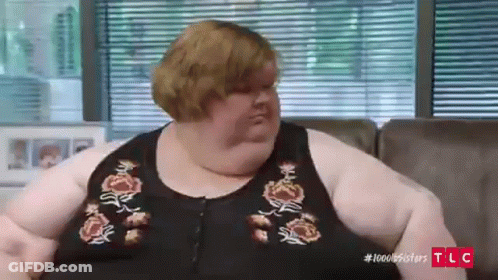 Very Fat Woman Sitting On Couch In Front Of Blinds GIF