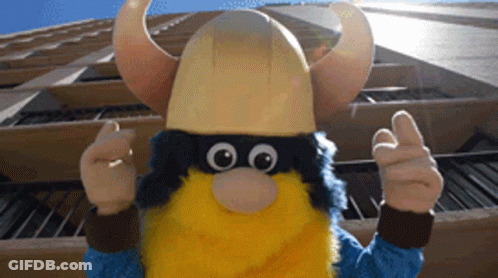 Viking Mascot Thumbs Up In Front Of Building GIF