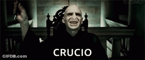 Voldemort From Harry Potter Is Sitting In A Chair With His Hands Up And The Word Crucio Written On His Face . GIF