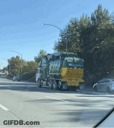 Volvo Garbage Truck Driving Down Street GIF