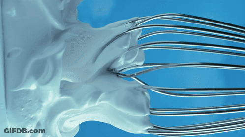 Whipped Cream Being Whisked On Blue Surface GIF
