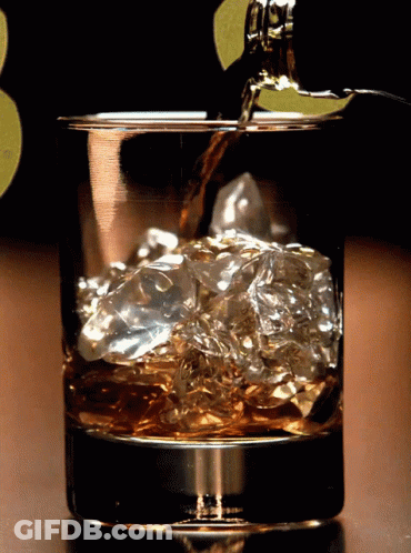 Whiskey Bottle Poured Into Ice Glass GIF