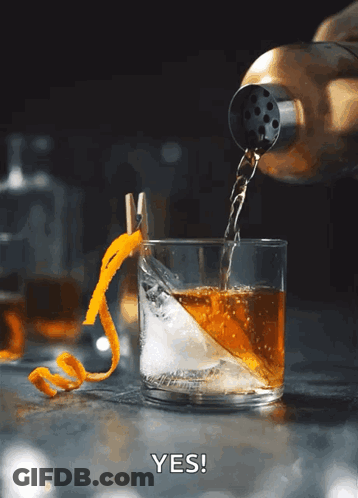 Whiskey Poured Into Iced Glass With Orange Peel GIF