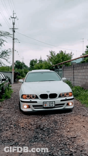 White BMW Parked On Gravel Road License Plate DZ-215 GIF