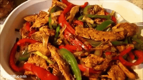 White Bowl Filled With Chicken Peppers And Onions GIF
