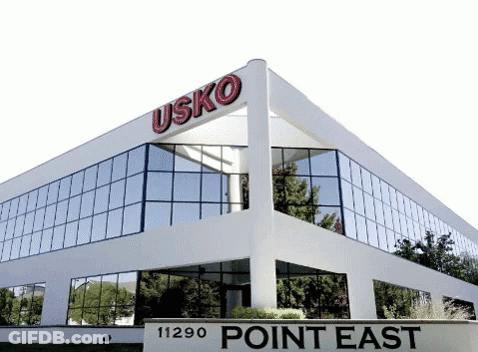 White Building With Point East Sign GIF