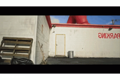 White Building With Red Lettering Saying EyXjaa9 GIF