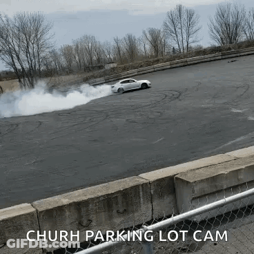 White Car Drifting With Smoke Church Parking Lot Cam GIF