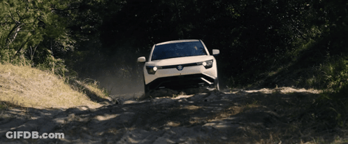 White Car Driving Down Dirt Road With Trees GIF
