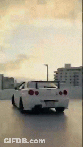White Car Driving In Parking Lot With City Background GIF
