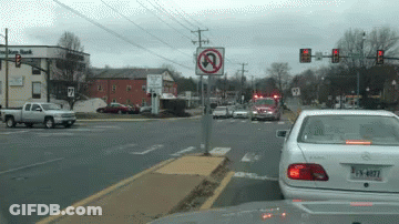 White Car Driving Past No Left Turn Sign GIF