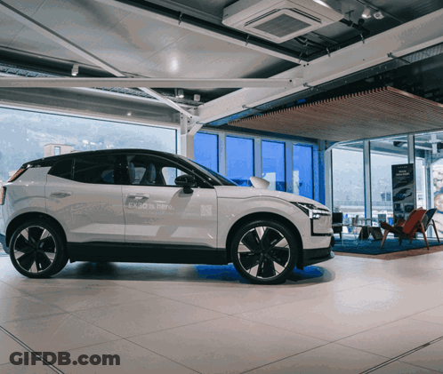 White Car In Showroom Saying Enjoy Is Here GIF