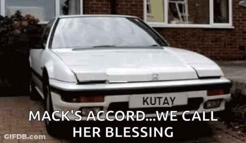 White Car With Kutyay License Plate And Brick House GIF