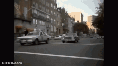 White Car With Number 1 Driving Down Street GIF