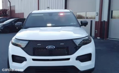 White Ford Police Car Parked In Front Of Garage With Red Light GIF