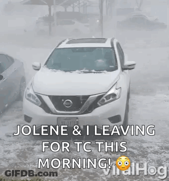 White Nissan SUV Driving Through Snowy Street GIF