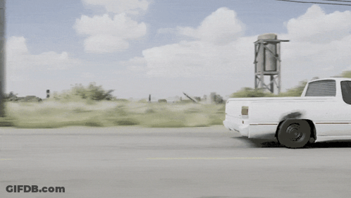 White Pickup Truck Driving Down Street GIF