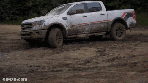 White Pickup Truck Driving Through Muddy Field GIF