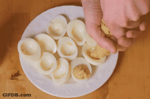 White Plate With Hard Boiled Eggs Stuffed With Mustard GIF