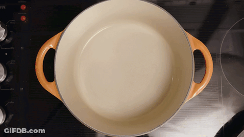 White Pot With Orange Handles On Stove GIF