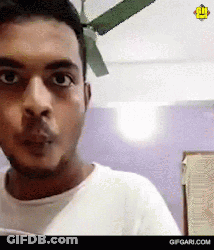White Shirt Man Looking At Camera, Ceiling Fan GIF