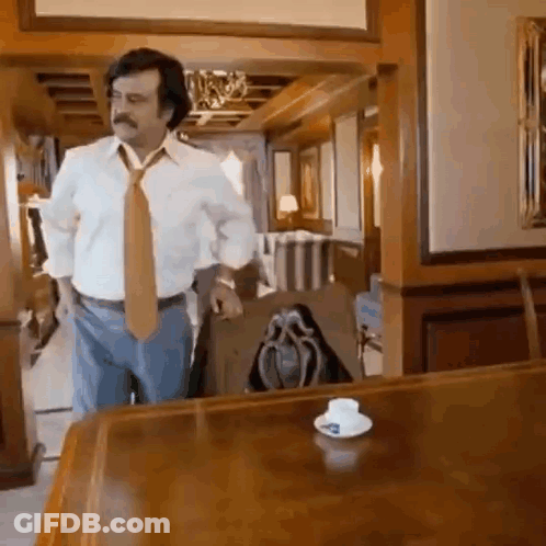 White Shirt Tie Man By Wooden Table With Cup GIF