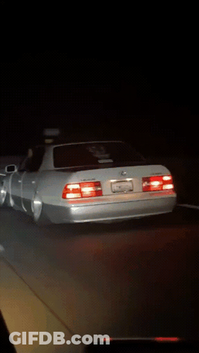 White Sports Car Parked In Dark Parking Lot At Night GIF