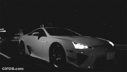 White Sports Car Parked In Dark Parking Lot At Night GIF