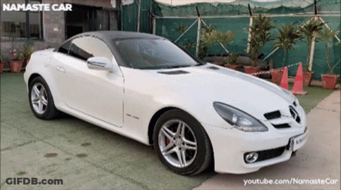 White Sports Car Parked In Front Of Namaste Car YouTube Channel GIF