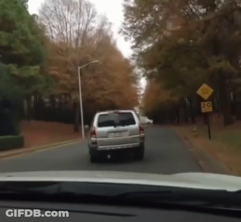 White SUV Driving Down Road With 20 Sign GIF