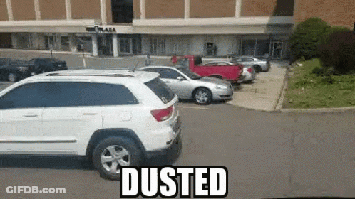 White SUV Parked Near Dusted Building GIF